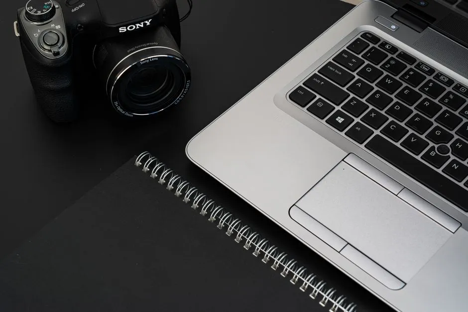 A laptop and notebook on an office desk